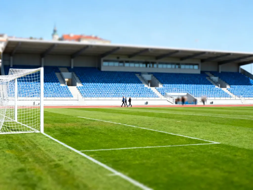 Nowoczesny Stadion Miejski w Gdyni z widokiem na murawę i trybuny z niebieskimi krzesełkami w słoneczny dzień